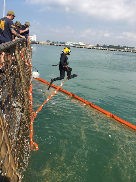 Người nhái của hải quân Mỹ xuống biển tìm kiếm thủy thủ còn mất tích quanh tàu USS John S. McCain đang neo đậu ở căn cứ hải quân Changi tại Singapore ngày 23-8 - Ảnh: REUTERS