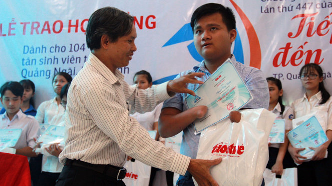 Ông Nguyên, trưởng ban dân vận tỉnh Quảng Ngãi trao quà cho tân sinh viên - Ảnh: TRẦN MAI