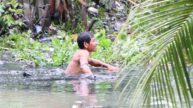 Ông Dương Minh Dũng – một người dân đến từ An Giang tình nguyện xuống dòng kênh vớt rác - Ảnh: P.H