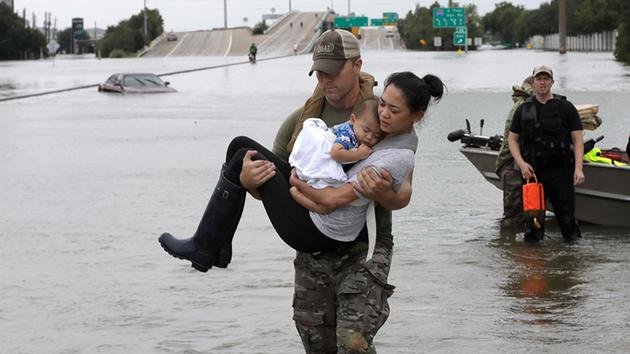 Tấm ảnh sĩ quan Daryl Hudeck của đội phản ứng nhanh SWAT ở TP Houston bồng cô Catherine Pham - một người Mỹ gốc Việt, cùng con trai tên Aiden đưa đi di tản khỏi nhà của họ đã trở thành tấm ảnh biểu tưởng về hoạt động cứu hộ trong trận bão Harvey - Ảnh: AP