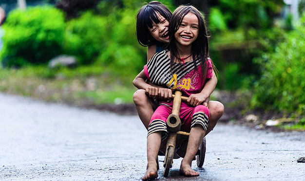 Sơn La: Tôi bắt gặp những em bé này trên quốc lộ 43 thuộc huyện Gia Phù, một huyện nghèo miền núi của tỉnh Sơn La. Những chiếc xe tự chế bằng thân tre, những bộ áo quần lấm lem bùn đất nhưng không làm tắt nụ cười hồn nhiên, trong trẻo trên gương mặt các em - Ảnh: Nguyễn Ngọc Thái