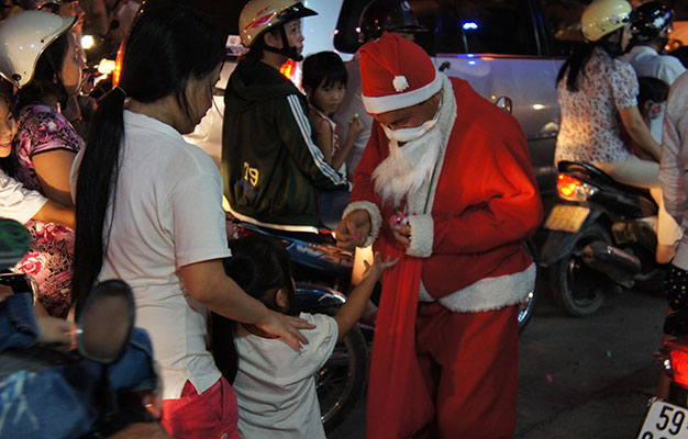 Mỗi dịp Noel về, các phong trào thiện nguyện của người trẻ lại rộn ràng. Một bạn trẻ hóa trang thành  ông già Noel phát kẹo cho trẻ em trên đường Tô Ngọc Vân (Q.Thủ Đức, TP.HCM) - Ảnh: Hải Thi