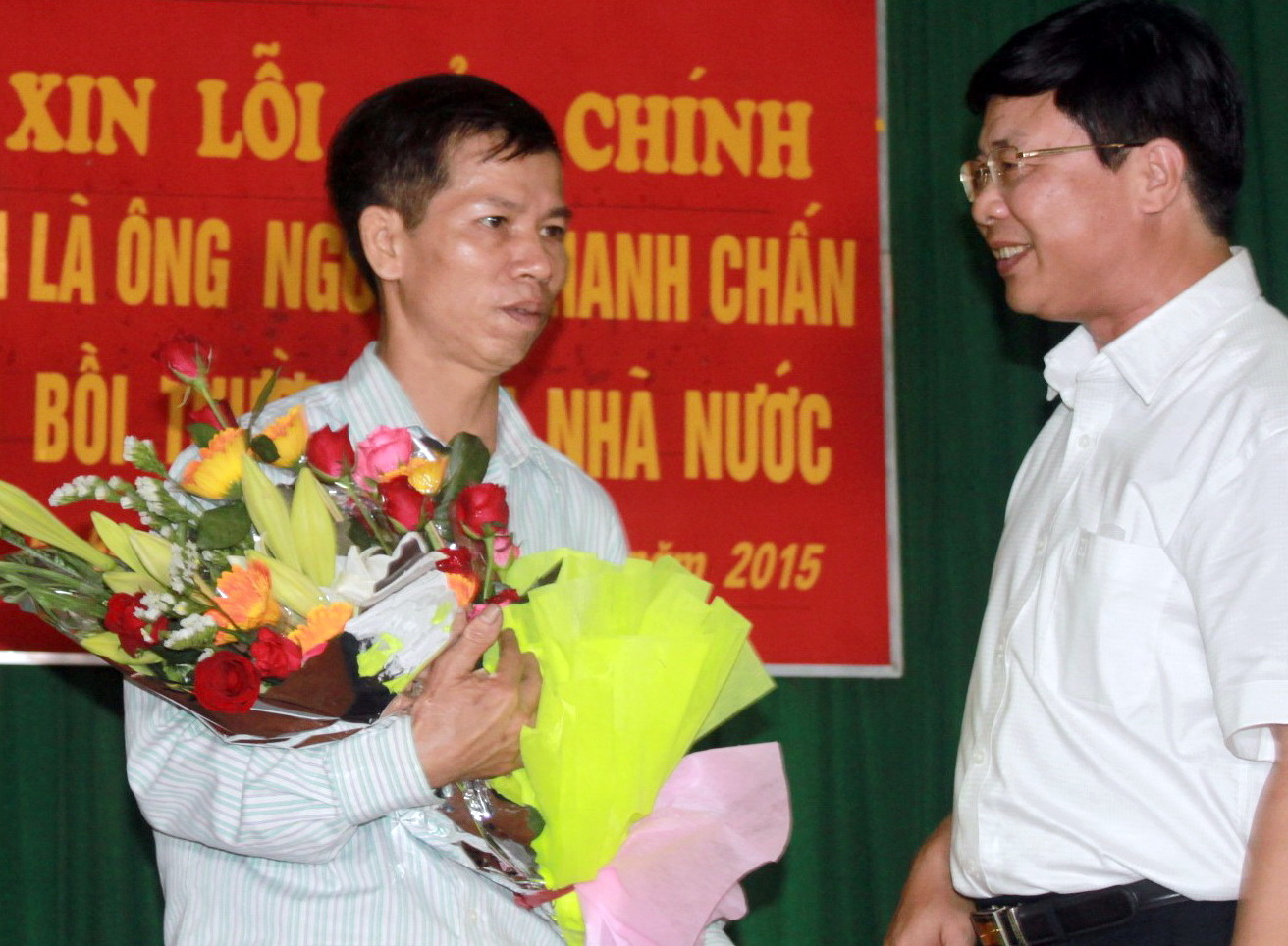 Ông Chấn (trái) xúc động nhận hoa do đại diện Tòa án nhân dân Tối cao trao tặng trong buổi xin lỗi công khai ngày 17-4- Ảnh: Tâm Lụa