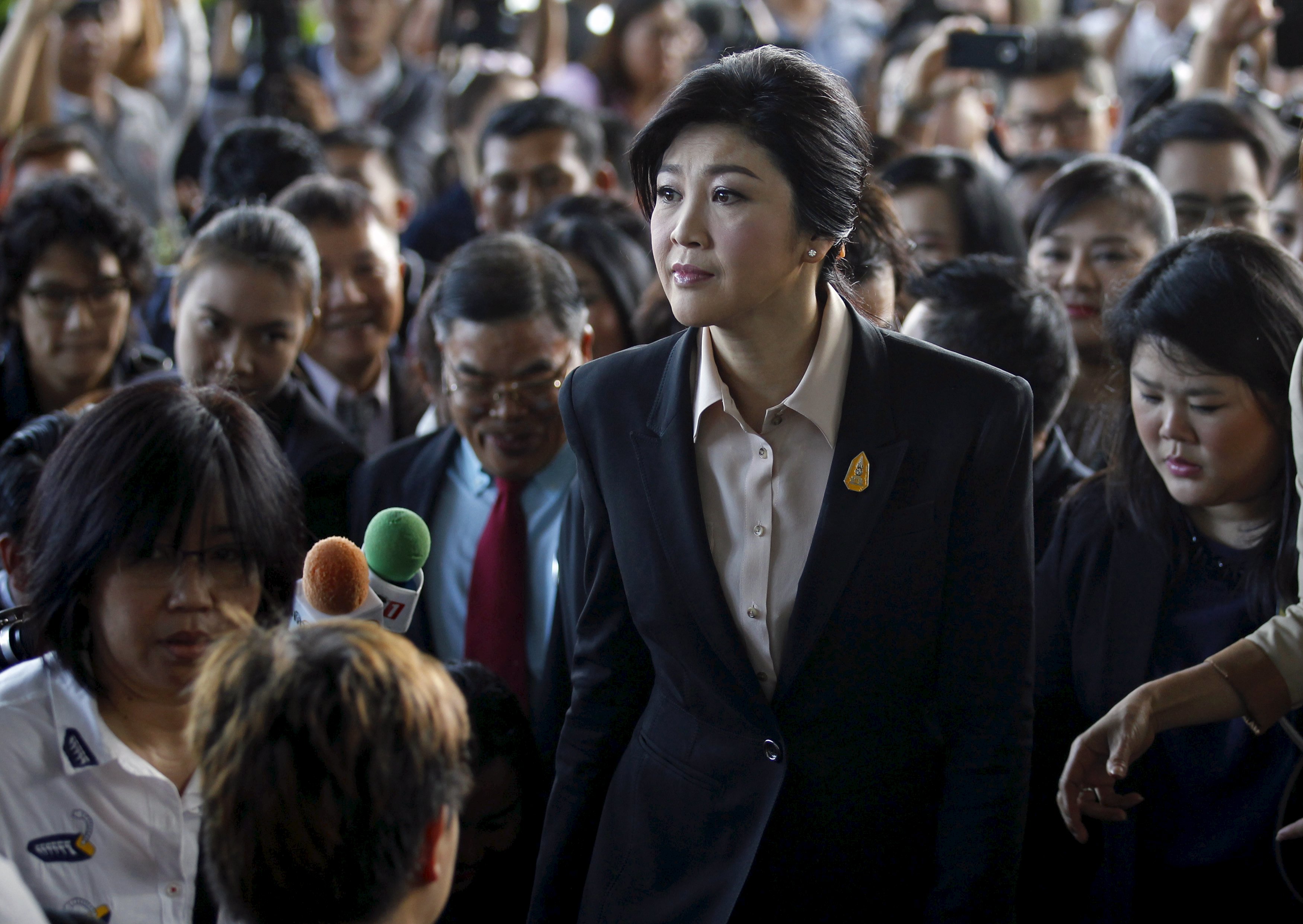Bà Yingluck băng qua đám đông trước tòa án tối cao Thái Lan ở Bangkok ngày 19-5 - Ảnh: Reuters