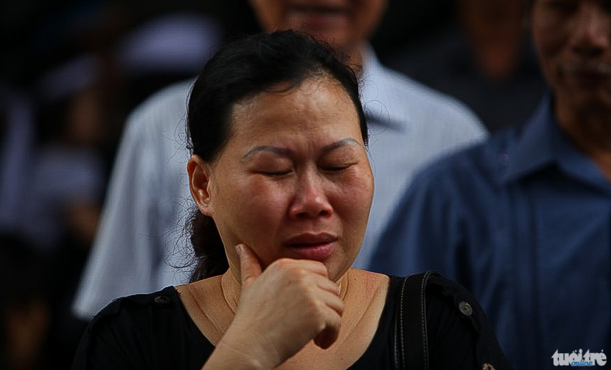 Một phụ nữ khóc nức nở khi vào viếng các liệt sĩ - Ảnh: NAM TRẦN
