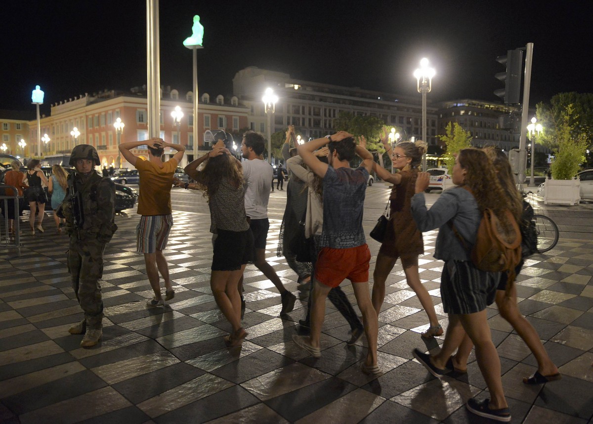 Từng dòng người bỏ tay sau gáy đi theo sự hướng dẫn, bảo vệ của cảnh sát sau vụ khủng bố - Ảnh: REUTERS