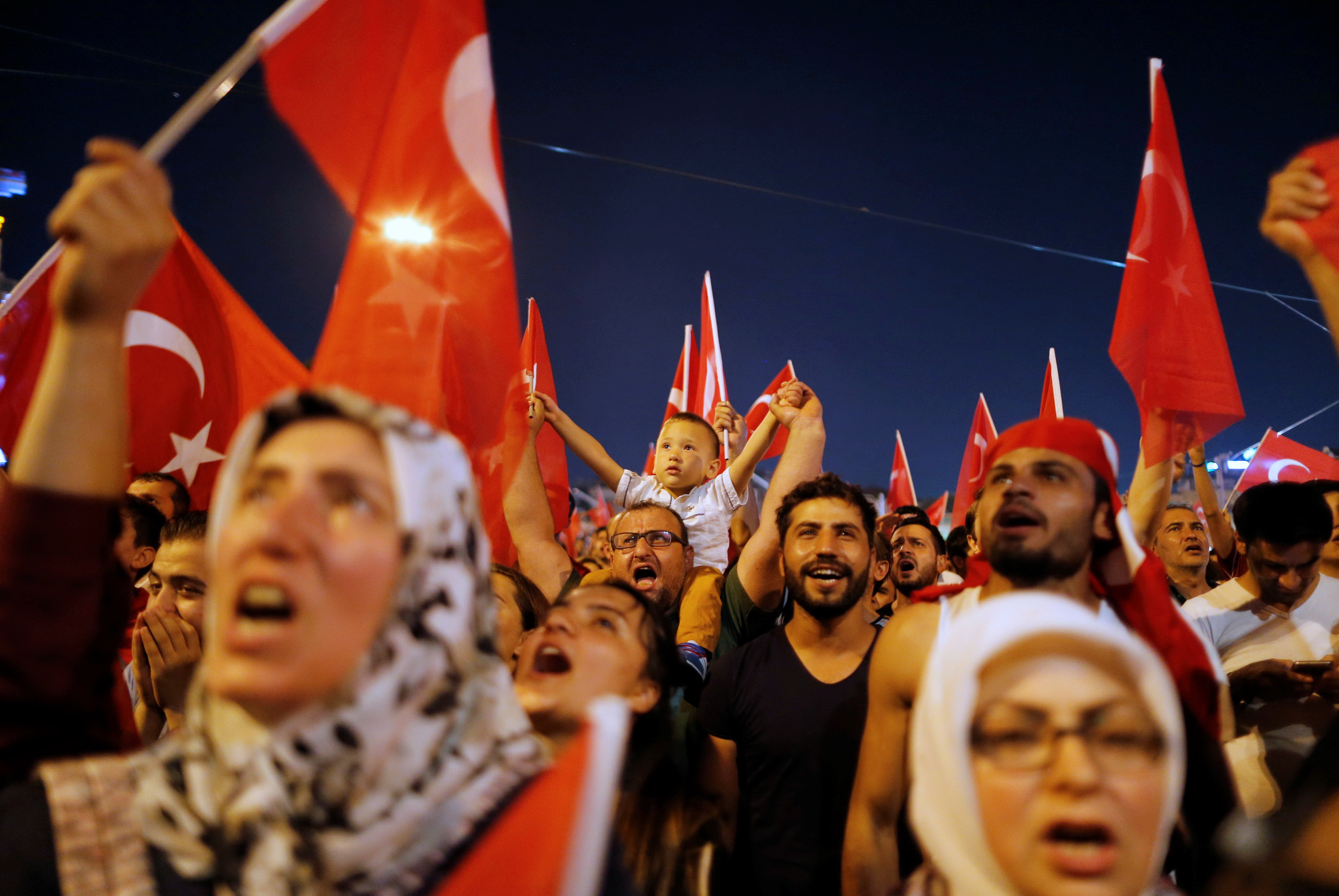 Nhiều người dân Thổ Nhĩ Kỳ, gồm cả phụ nữ và trẻ em, xuống đường ủng hộ Tổng thống Erdogan ở quảng trường Taksim, trung tâm thành phố Istanbul tối 16-7 - Ảnh: Reuters