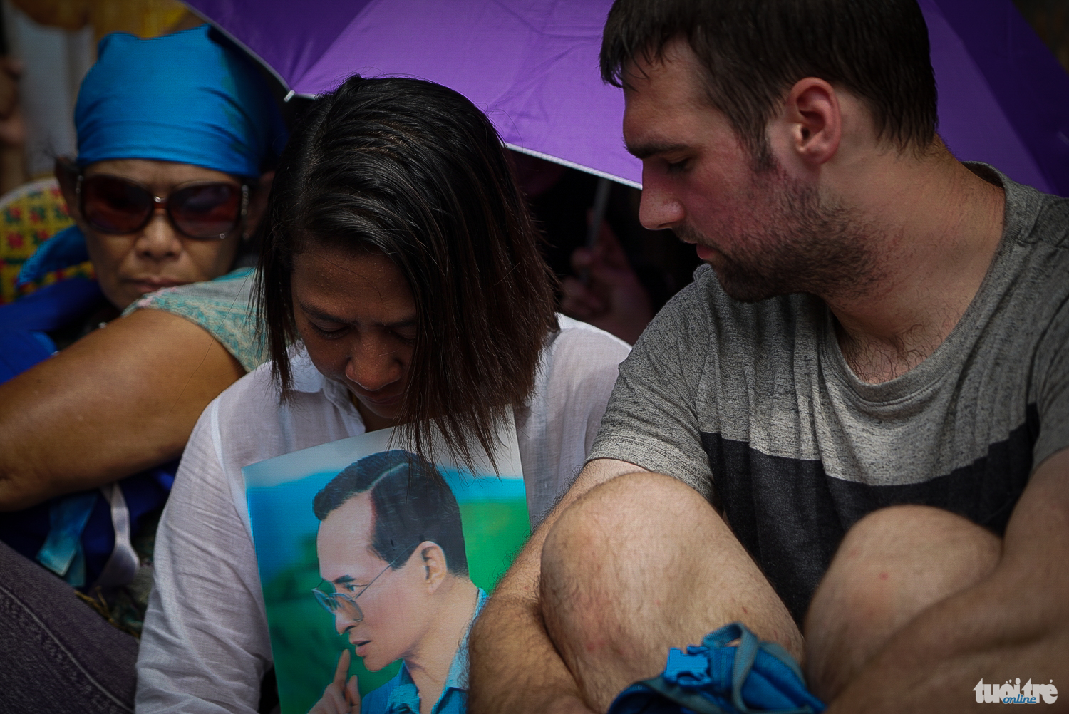 Một khách du lịch nước ngoài an ủi người dân Thái đang khóc nức nở trước cổng Hoàng Cung - Ảnh: Thuận Thắng