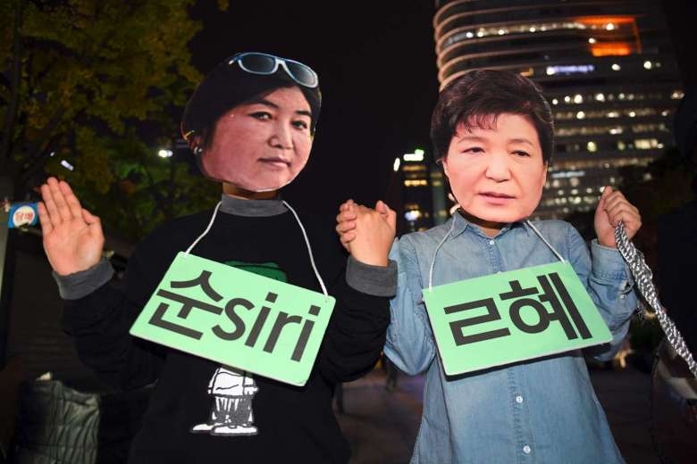 Người biểu tình đeo mặt nạ của Tổng thống Hàn Quốc Park Geun Hye (phải) và 