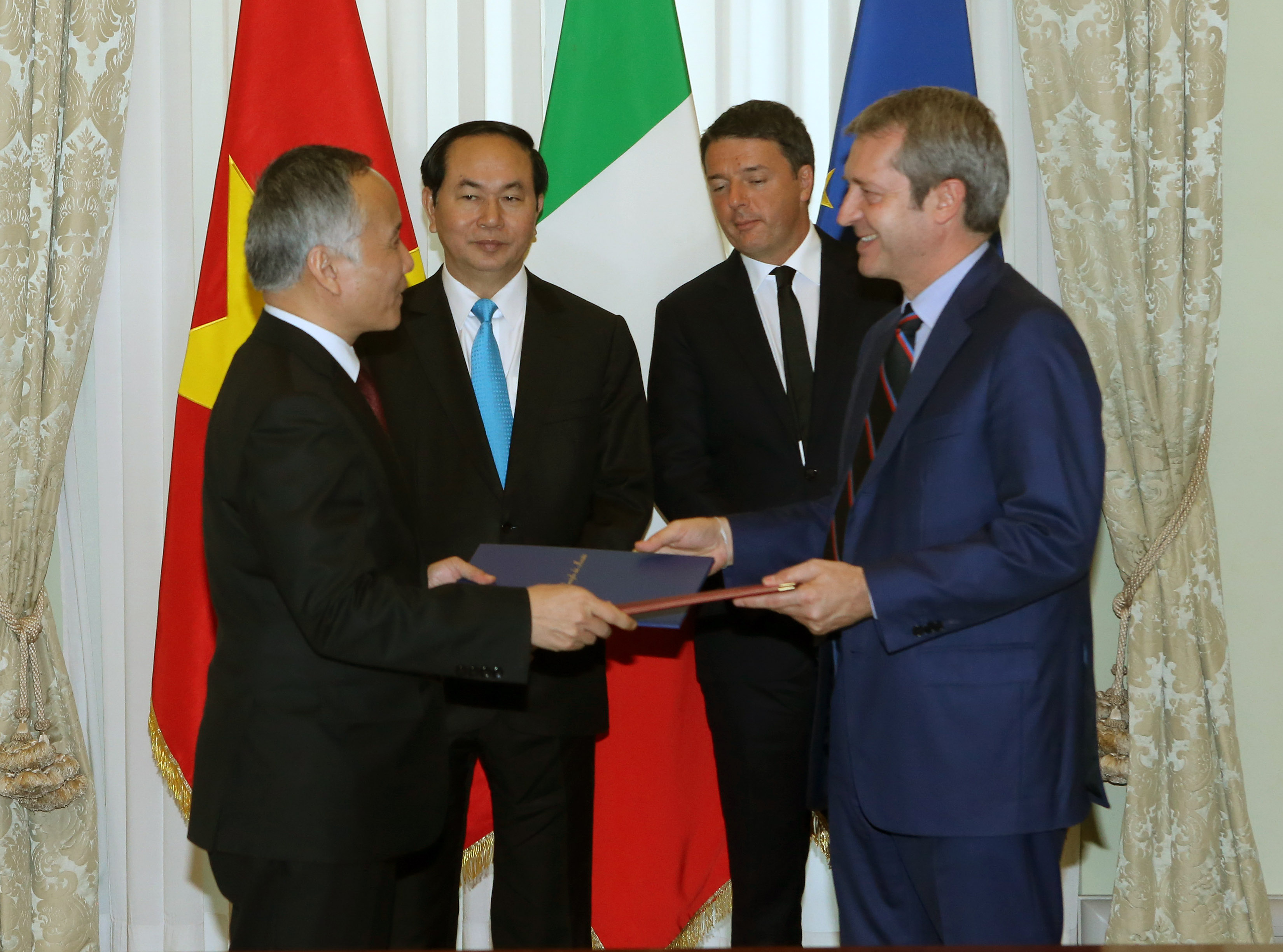 Chủ tịch nước Trần Đại Quang và Thủ tướng Ý Matteo Renzi chứng kiến lễ trao văn bản hợp tác - Ảnh: TTXVN