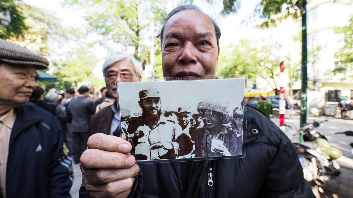 Ông Cao Khắc Thuận - 82 tuổi, một người từng học tập tại Cuba cầm bức ảnh ông được chụp ảnh chung với  chủ tịch Fidel Castro tại Cuba năm 1966 - Ảnh: Nguyễn Khánh