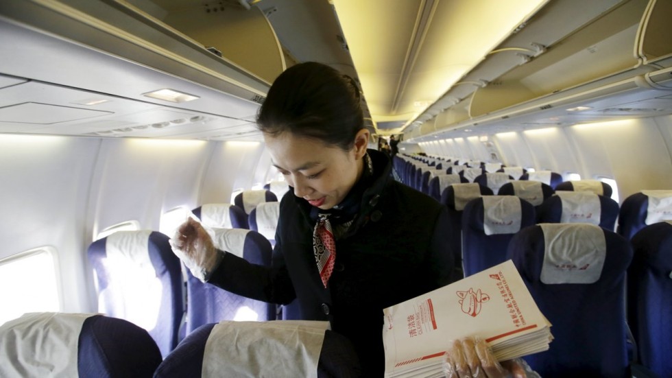 Một tiếp viên của hãng China United Airlines đang dọn dẹp sau một chuyến bay đến Bắc Kinh - Ảnh: Reuters