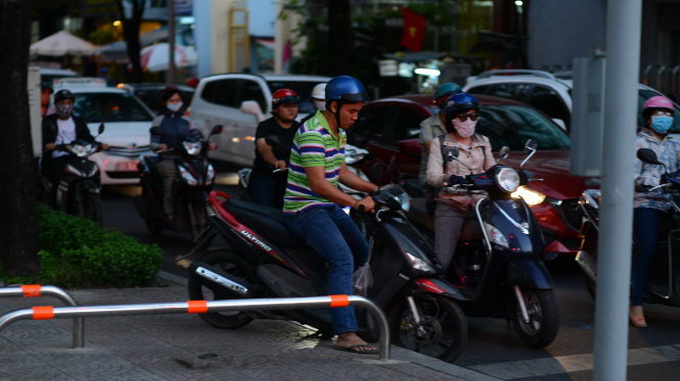 Tình trạng kẹt xe diễn ra hiện nay khiến nhiều người phải leo xe máy lên vỉa hè. Trong ảnh: xe máy leo vỉa hè trên đường Nguyễn Bỉnh Khiêm, Q.1, TP.HCM chiều 11-2 - Ảnh: Q.ĐỊNH