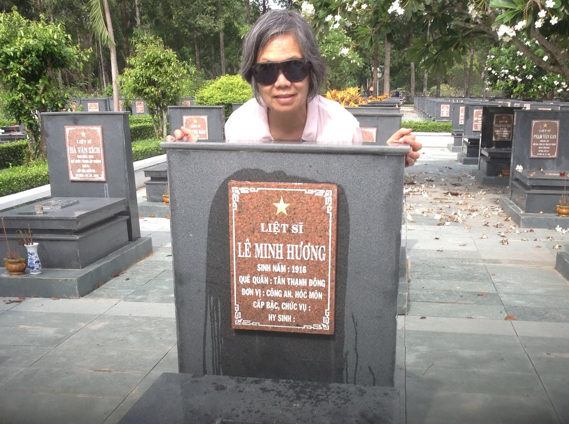Bà Châu bên cạnh phần mộ của cha mình - liệt sĩ Lê Minh Hương. Ảnh: NVCC