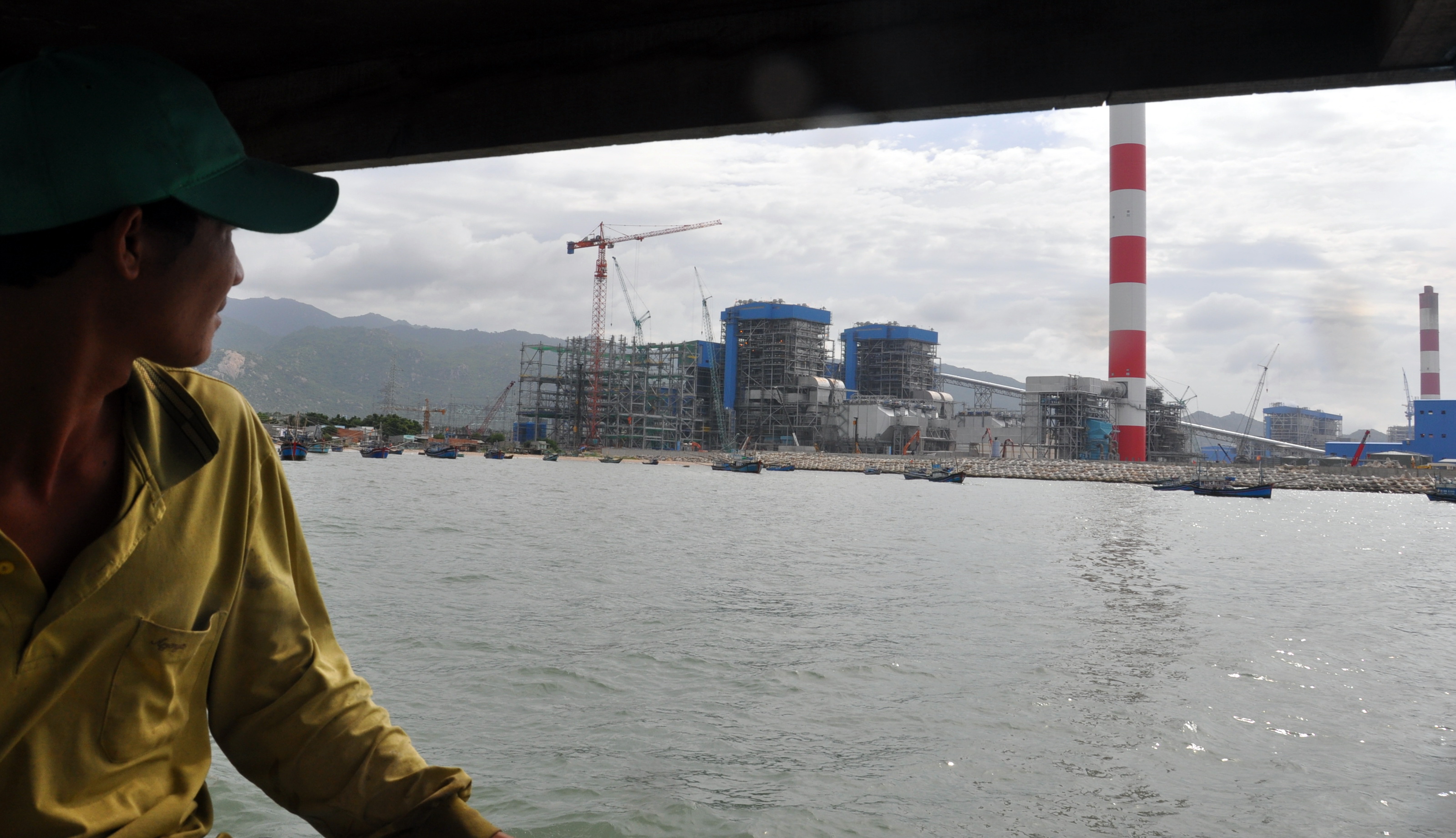 Anh Hà Đức Sỹ lo lắng khi nhìn về cụm Nhà máy nhiệt điện Vĩnh Tân - Ảnh: ĐÔNG HÀ