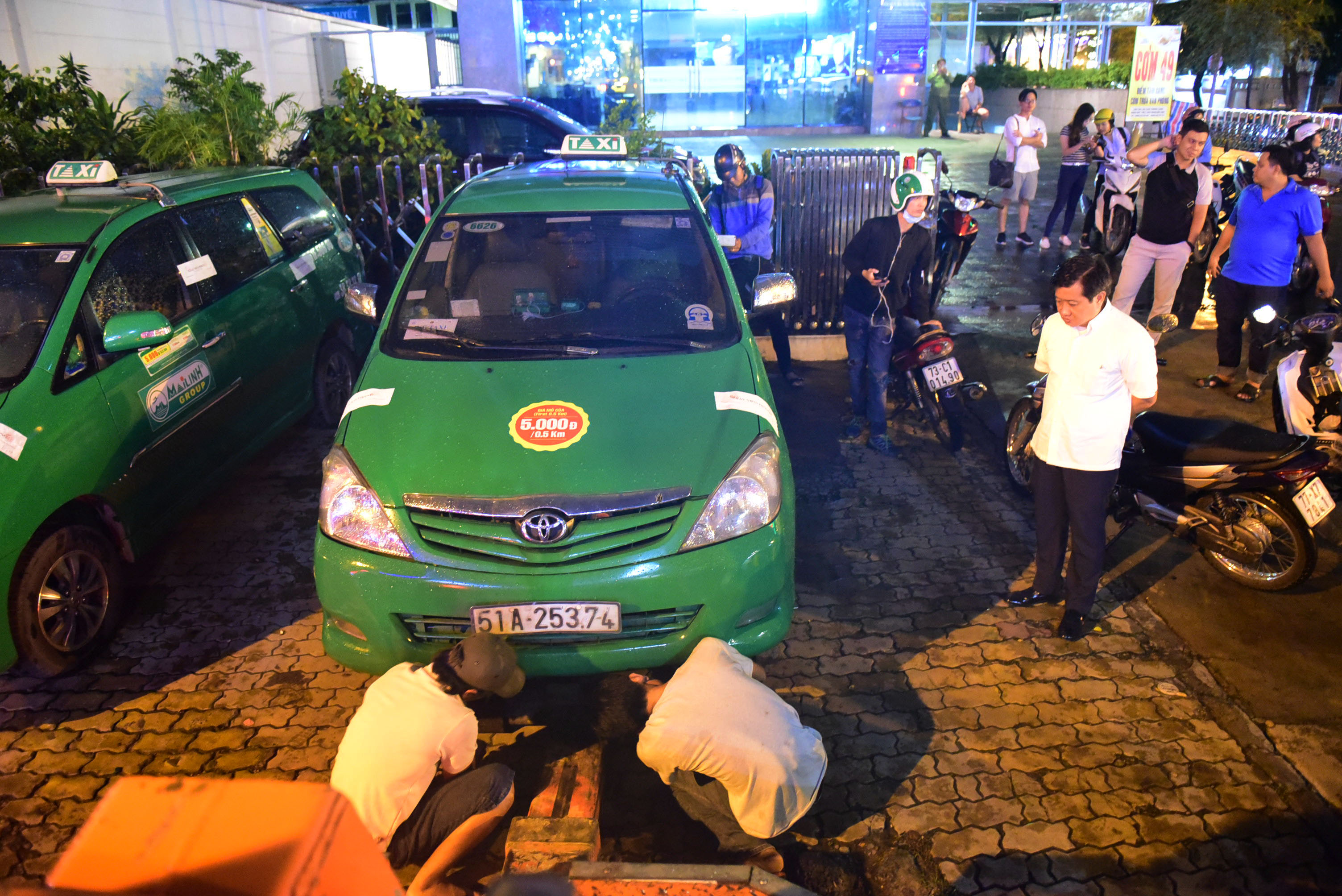 Niêm phong 4 chiếc xe taxi đậu trên vỉa hè đường Nguyễn Thị Minh Khai để cẩu về phường - Ảnh: HỮU THUẬN