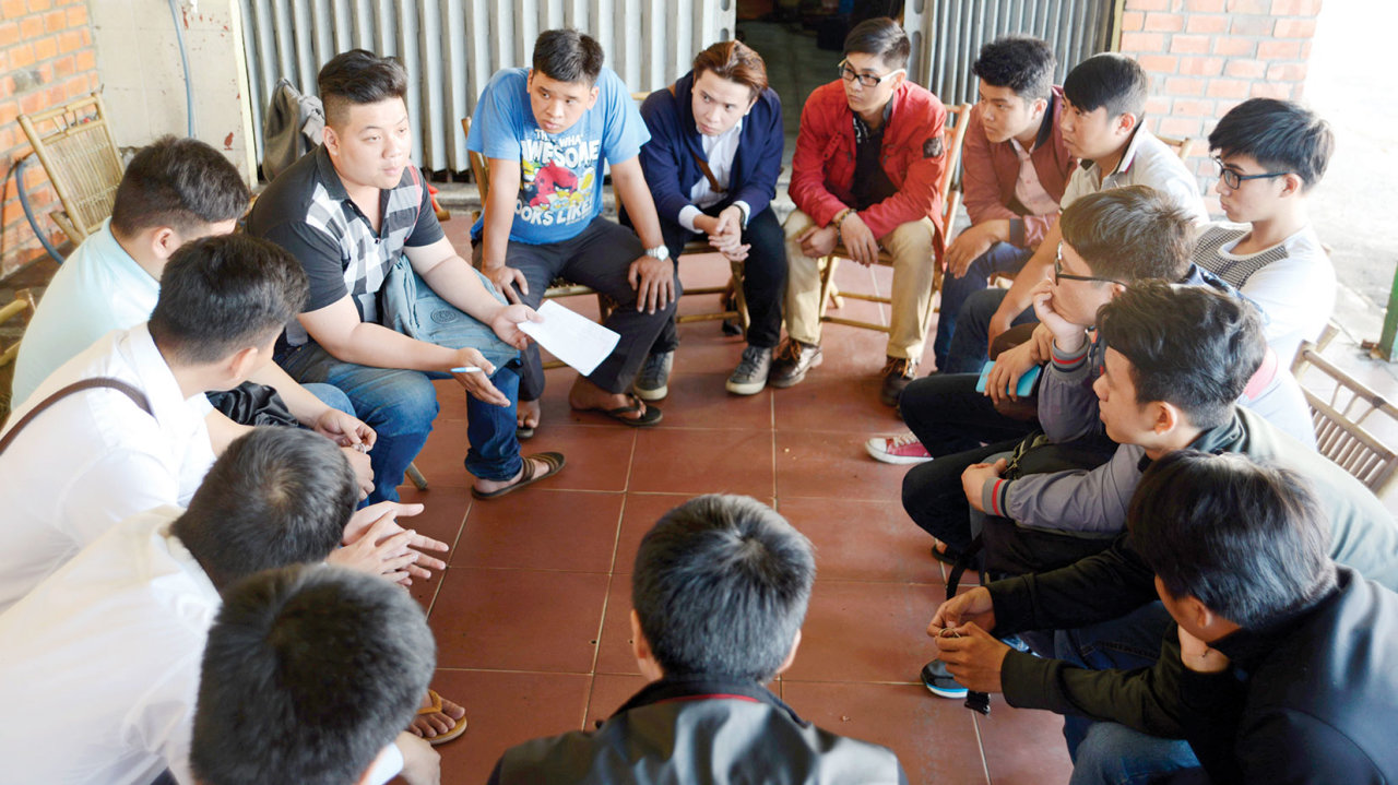Anh Nguyễn Bá Đạt (cầm giấy) trao đổi với các sinh viên về công việc cần phải làm và cách nói chuyện khi tặng quà cho các bé