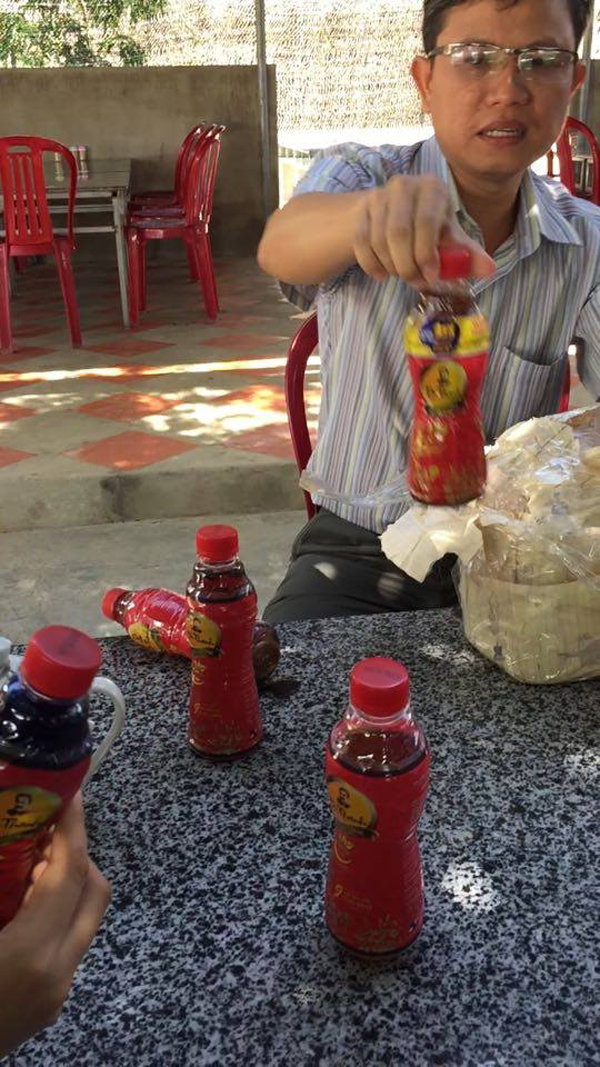 Ông Lâm Hoàng Hải, nhân viên của Tân Hiệp Phát, tháo niêm phong 6 chai trà Dr Thanh có ruồi mà ông Nguyễn Ngọc Anh đang giữ vào ngày 23-12 - Ảnh: KH.Nguyễn