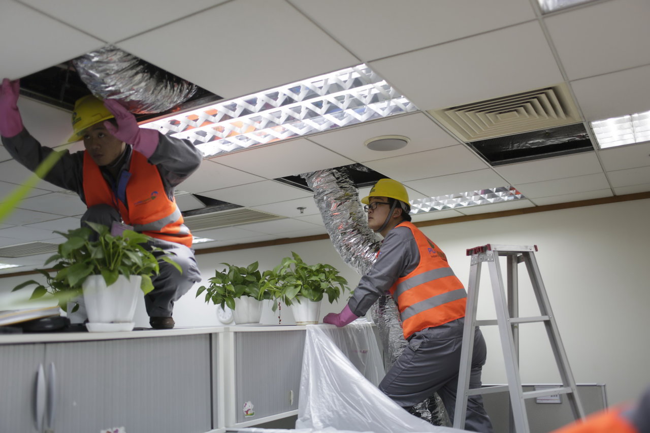 Lắp đặt hệ thống thông khí mới tại một văn phòng công ty ở Thượng Hải (Trung Quốc). Sau những năm tháng phát triển nóng, Trung Quốc đang trả giá từ nạn ô nhiễm - Ảnh: Reuters