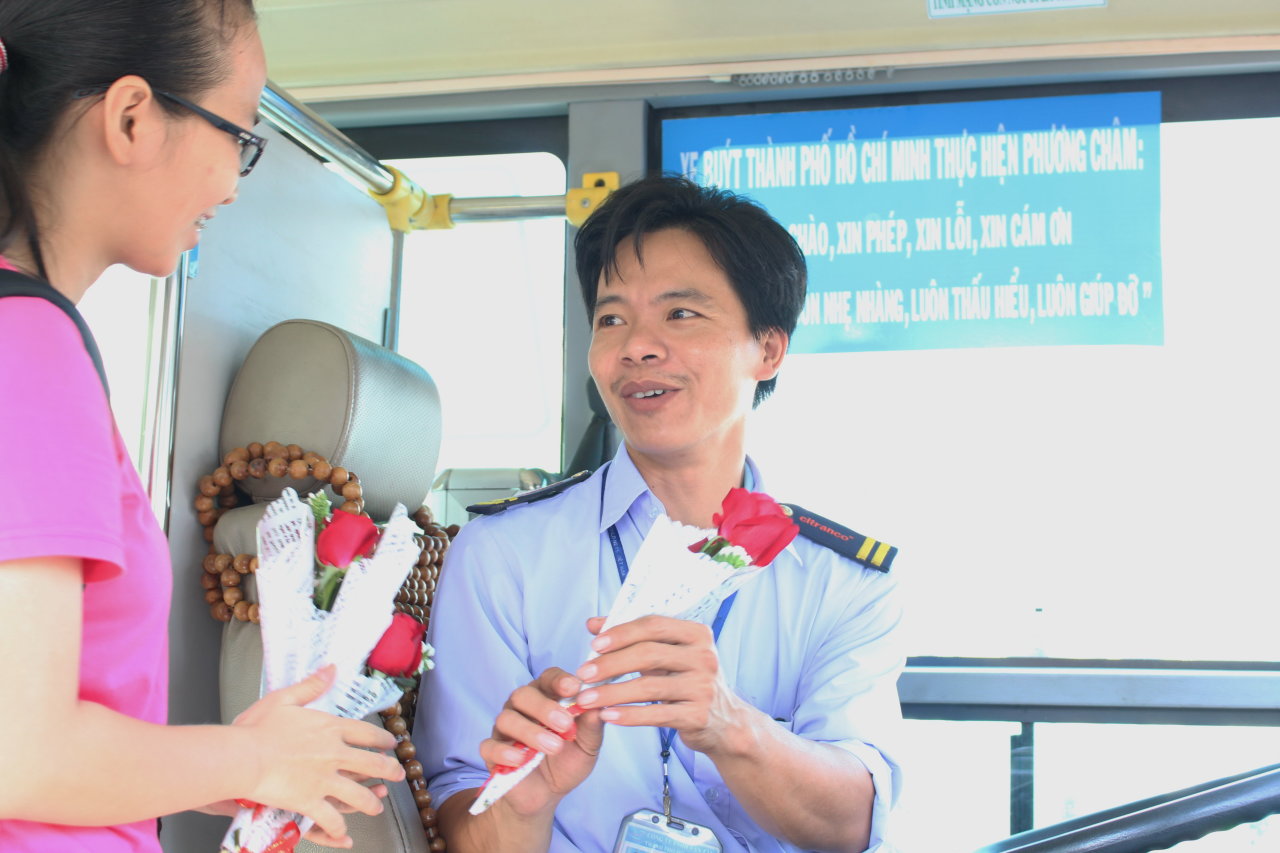 Thành viên nhóm Lớp học Hạnh Phúc trao hoa cho các tài xế xe buýt sáng 2-1-2016 - Ảnh: Tiểu Mi