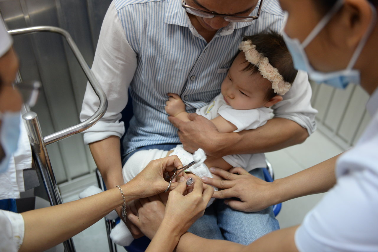 Người dân tiêm văcxin 5 trong 1 cho con tại Trung tâm Y tế dự phòng TP.HCM - Ảnh: Hữu Khoa