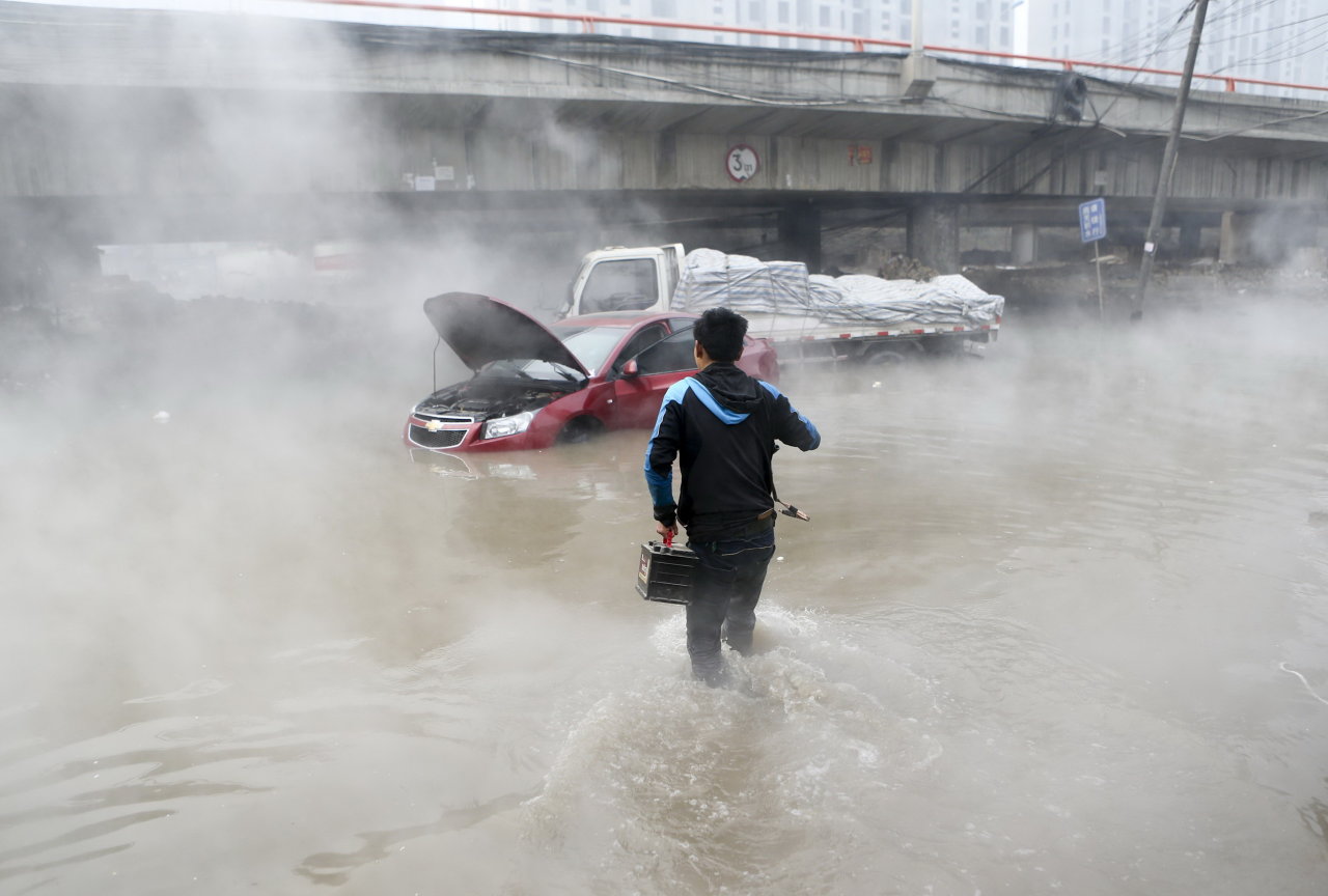 Cỗ xe kinh tế Trung Quốc đang có dấu hiệu khựng lại vì những khó khăn nội tại. Trong ảnh: nhân viên giải cứu xe chết máy do nước ngập tại tỉnh Thiểm Tây (Trung Quốc) ngày 6-1 - Ảnh: Reuters