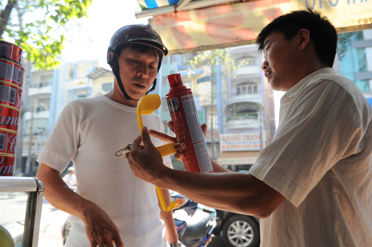 Một tài xế mua bình chữa cháy trên đường 
An Dương Vương, Q.5, TP.HCM - Ảnh: Tự Trung
