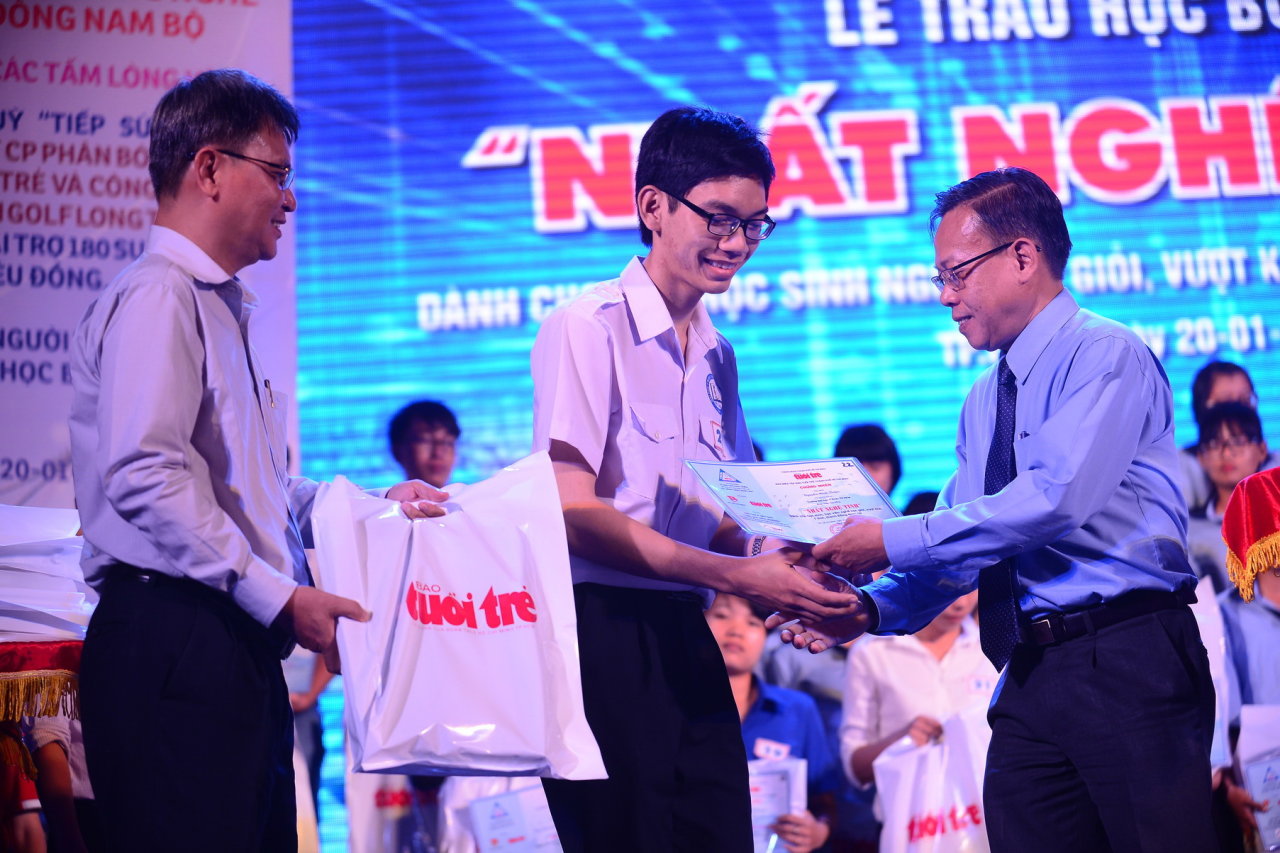 Phó trưởng ban thường trực ban tổ chức Thành ủy TP.HCM Nguyễn Hữu Hiệp (phải) và phó tổng biên tập Tuổi Trẻ Đỗ Văn Dũng (trái) trao học bổng cho các bạn - Ảnh: Quang Định