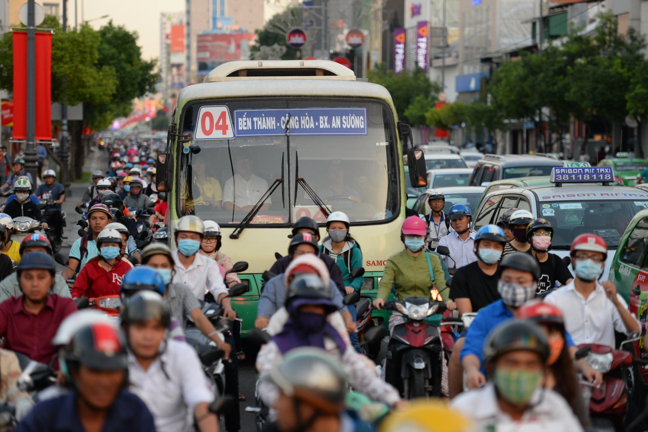 Một chiếc xe buýt giữa vòng vây xe máy trên đường Nguyễn Văn Trỗi hướng từ các quận trung tâm về sân bay Tân Sơn Nhất - Ảnh: Hữu Khoa