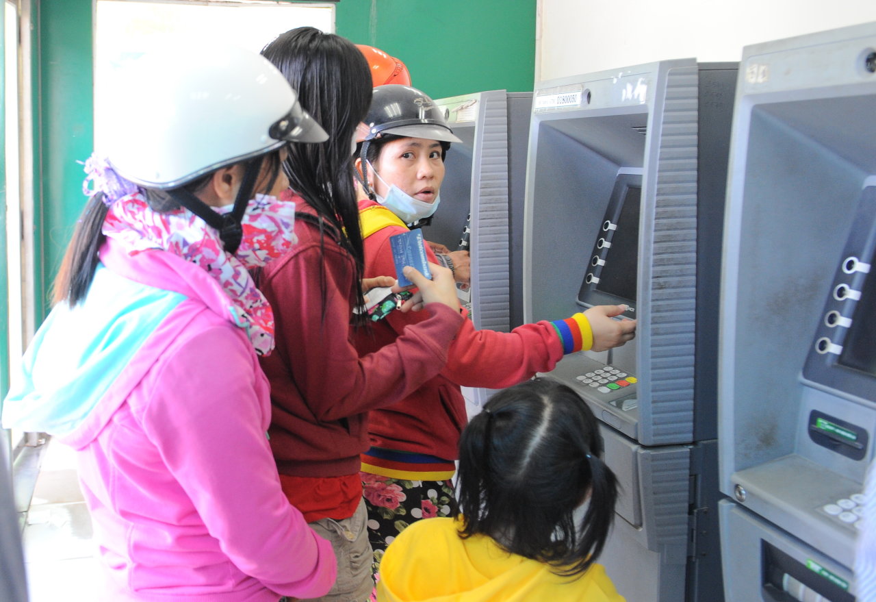 Công nhân làm việc tại Khu chế xuất Tân Thuận, Q.7, TP.HCM rút tiền từ máy ATM - Ảnh: Tự Trung