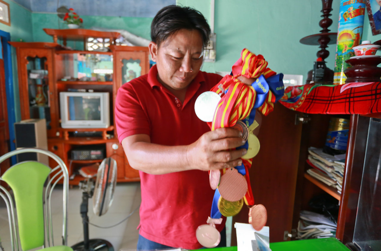 Ông Nguyễn Văn Biểu cầm những tấm huy chương của con gái đã giành được trong các cuộc thi taekwondo tổ chức trong nước và quốc tế
- Ảnh: Tiến Thành