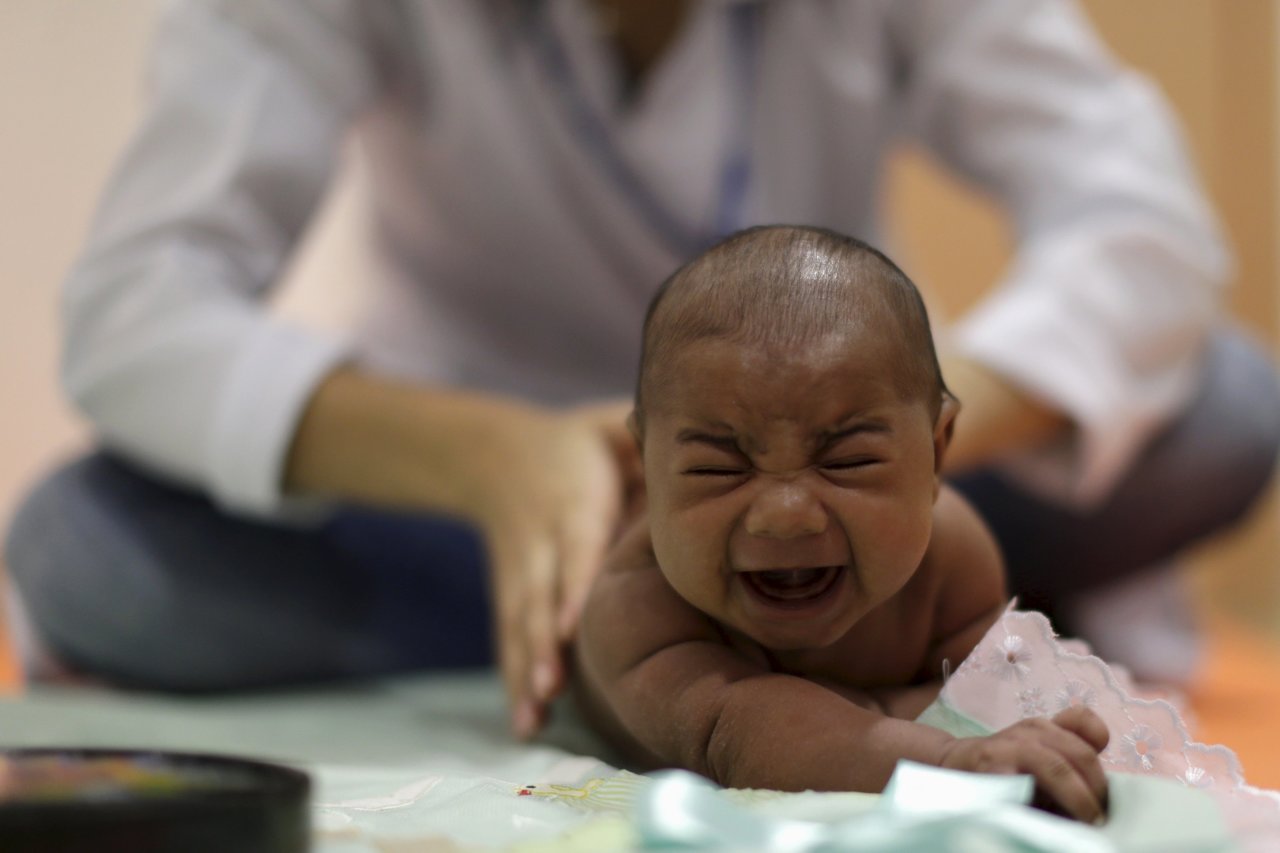 Một bé trai bị bệnh teo não do virút Zika được chăm sóc tại bệnh viện ở Recife, Brazil - Ảnh: Reuters