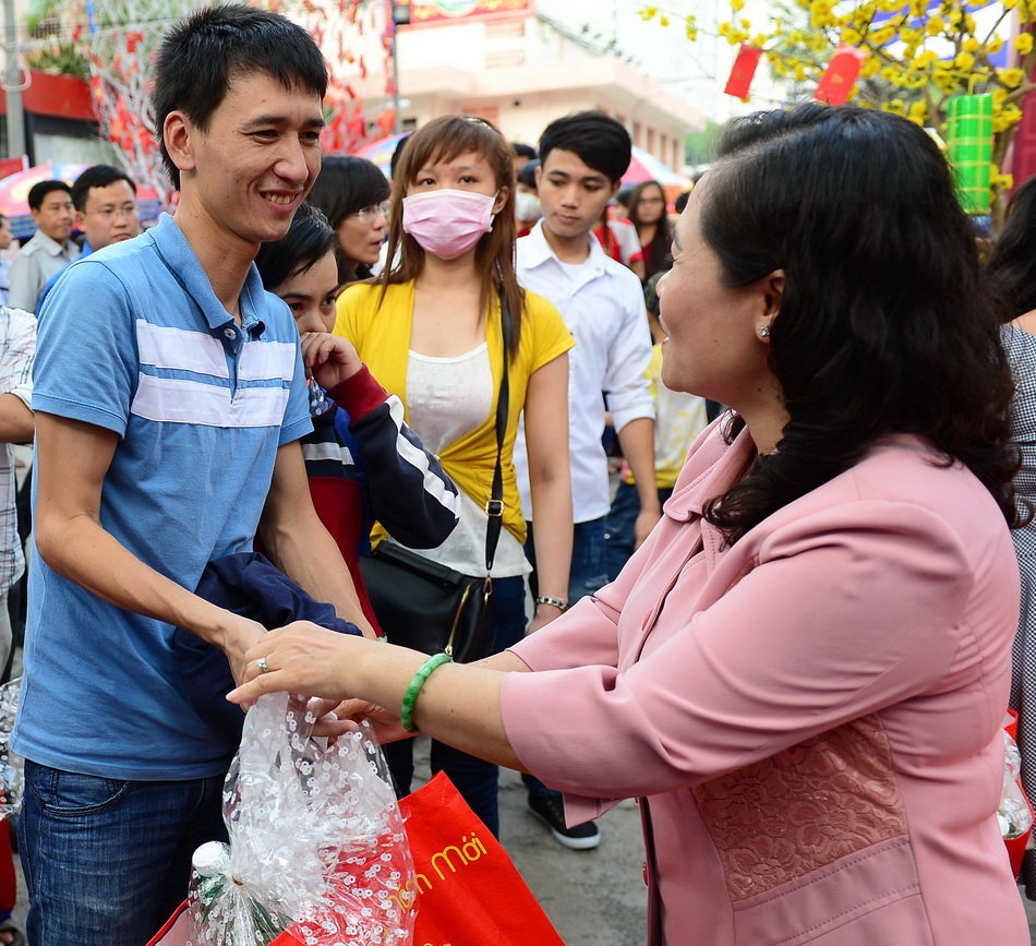 Trưởng ban Dân vận Thành ủy TP.HCM Nguyễn Thị Lệ trao quà, chúc sức khỏe các bạn công nhân trước giờ xe xuất bến - Ảnh: QUANG ĐỊNH