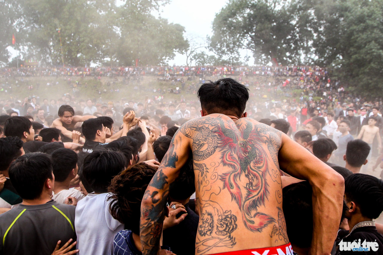 Một thanh niên xăm hình rồng phượng chuẩn bị lao vào đám đông để cướp phết - Ảnh: Nguyễn Khánh