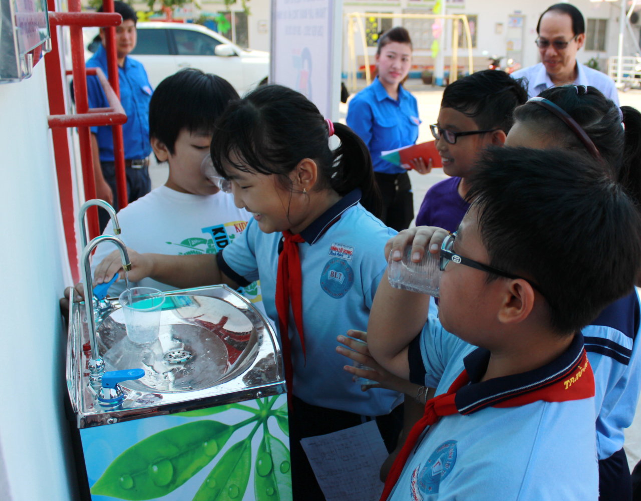 Các bạn nhỏ thích thú với vòi uống nước tại nguồn do Tổng công ty cấp nước Sài Gòn lắp tặng - Ảnh: Q.L.