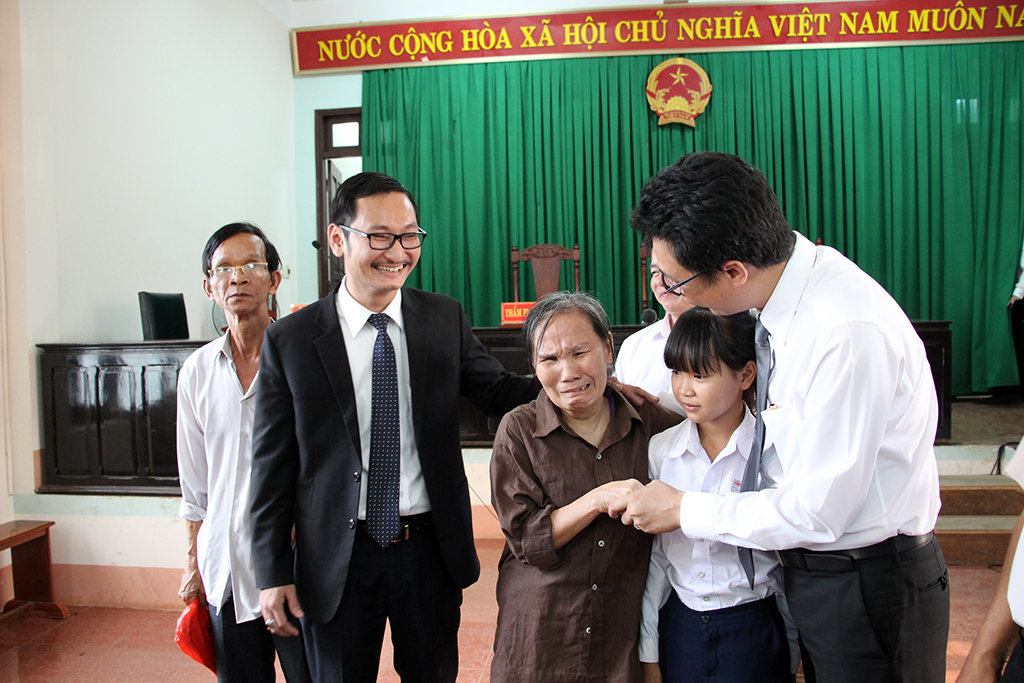 (Từ trái sang) ông Huynh, bà Tâm và cháu Hiếu cùng các luật sư sau khi kết thúc phiên tòa