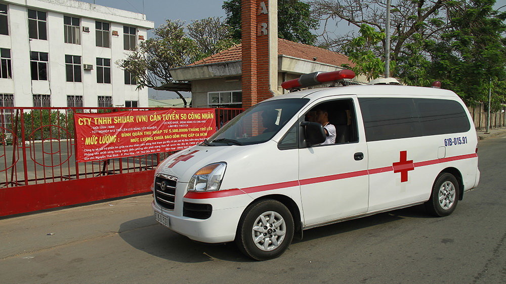 Xe cứu thương vào khu vực công ty đưa thi thể nạn nhân ra ngoài - Ảnh: Xuân An