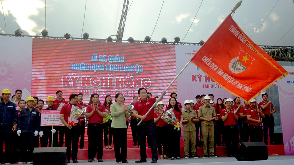 Bà Võ Thị Dung (trái) phó bí thư Thành ủy TP.HCM trao cờ lệnh cho chỉ huy trưởng chiến dịch kỳ nghỉ hồng năm 2016 anh Phùng Thái Quang - Ảnh: QUANG PHƯƠNG