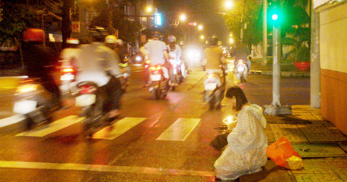 Người phụ nữ trẻ quỳ xin tiền hàng đêm ở ngã tư Cách Mạng Tháng Tám - Nguyễn Đình Chiểu, ngay vạch đậu xe. Ảnh chụp 0g sáng 31-7 - Ảnh: THANH MINH