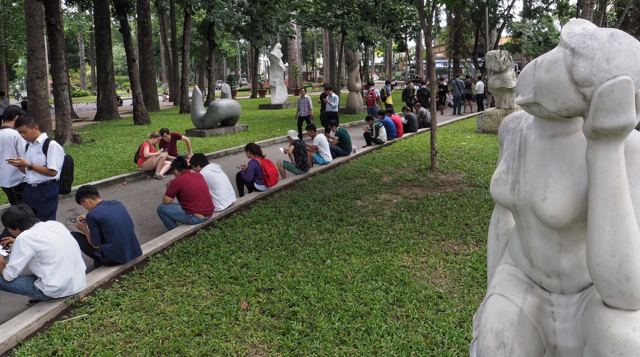 Các game thủ ngồi kín công viên Tao Đàn chờ con Pokémon xuất hiện - Ảnh: CƯƠNG TRẦN