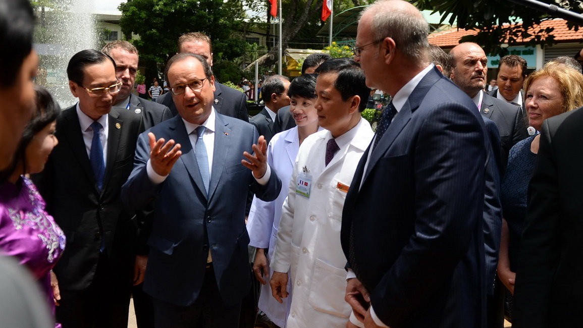 Tổng thống Pháp Francois Hollande trò chuyện với Bộ trưởng Bộ Y tế Nguyễn Thị Kim Tiến và các bác sĩ Viện Tim - Ảnh: HỮU KHOA