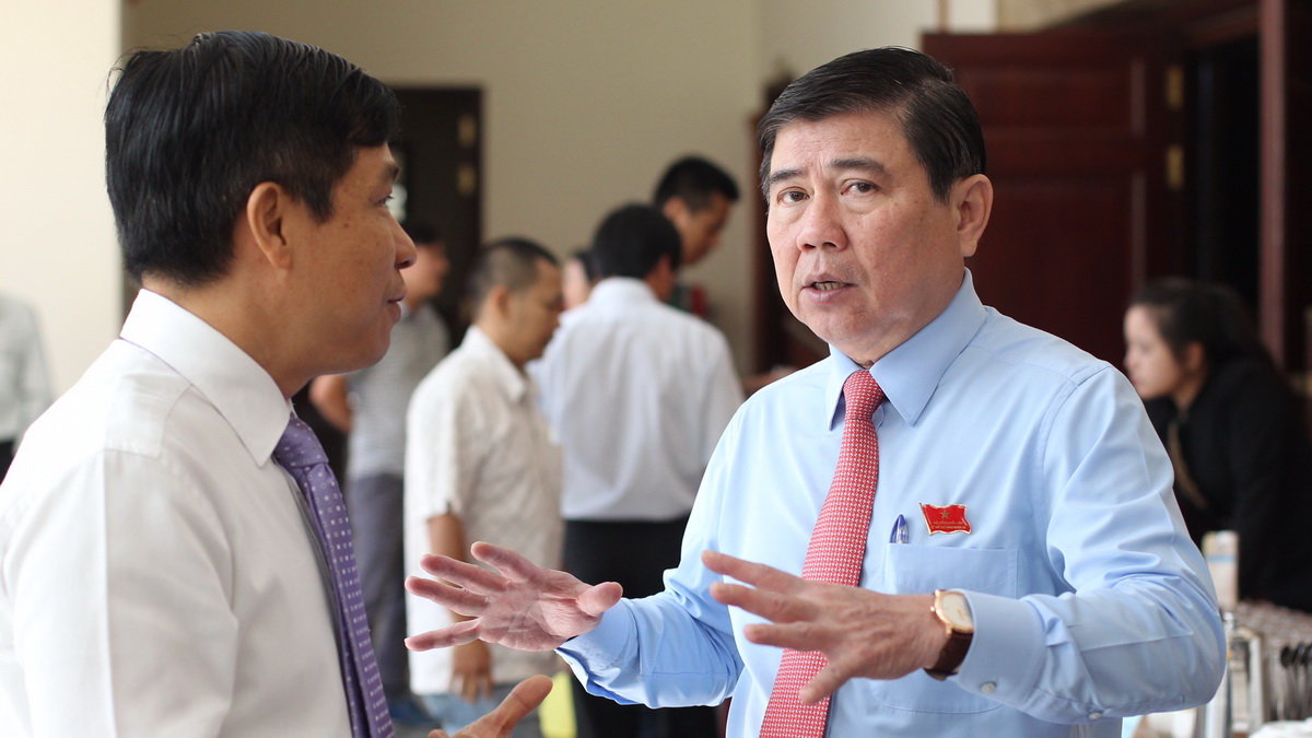 Ông Nguyễn Thành Phong (phải) trao đổi với với đại biểu bên lề cuộc họp HĐND TP.HCM ngày 6-12 - Ảnh: Tự Trung