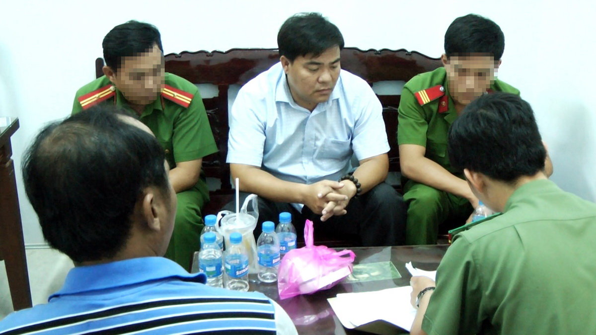 Ông Châu Hoài Phương (giữa) Phó Chi cục trưởng Chi cục QLTT Sóc Trăng bị công an bắt giữ