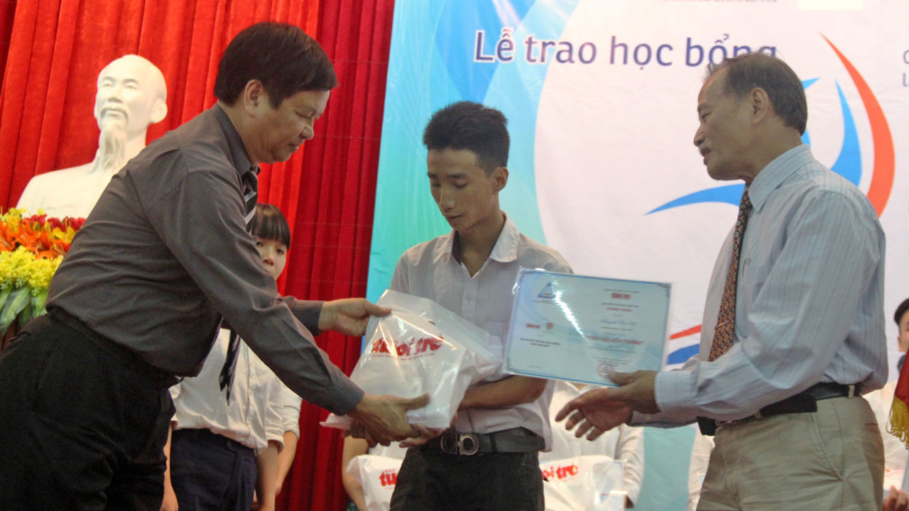 Ông Nguyễn Dung (trái) và PGS. TS Nguyễn Thiện Tống trao học bổng đến các tân sinh viên - Ảnh: MINH AN