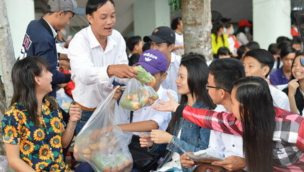 Thầy Nguyễn Vũ Hoàng Vĩnh Tường, chia bánh mì cho học trò lót dạ trước khi bước vào buổi tư vấn - Ảnh: Ngọc Tài
