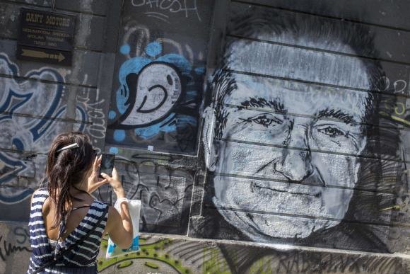 Một người hâm mộ chụp bức tranh vẽ Robin Williams tại Belgrade (Serbia) hôm 13-8 - Ảnh: Reuters