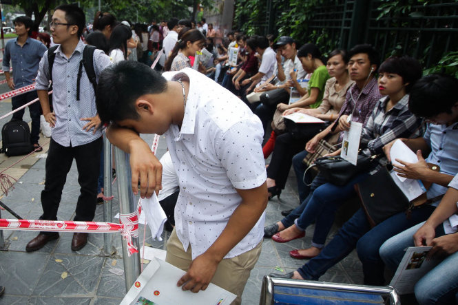 Một chàng trai mệt mỏi khi phải chờ đợi quá lâu để nộp hồ sơ - Ảnh: Nguyễn Khánh