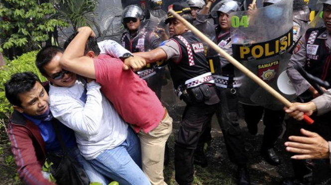 Cảnh sát đụng độ với người biểu tình bên ngoài trụ sở tòa án hiến pháp Indonesia - Ảnh: AP