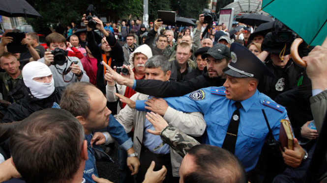 Cảnh sát Ukraine ngăn cản người biểu tình trước lối vào trụ sở Bộ quốc phòng - Ảnh: Reuters