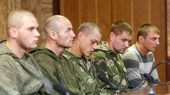 Nhóm binh sĩ Nga bị bắt được dẫn giải đến buổi họp báo tại Kiev ngày 27-8. Phía Ukraine cáo buộc nhóm lính dù này xâm nhập lãnh thổ Ukraine cho một “nhiệm vụ đặc biệt”, trong khi phía Nga khẳng định nhóm này “đi lạc” - Ảnh: Reuters